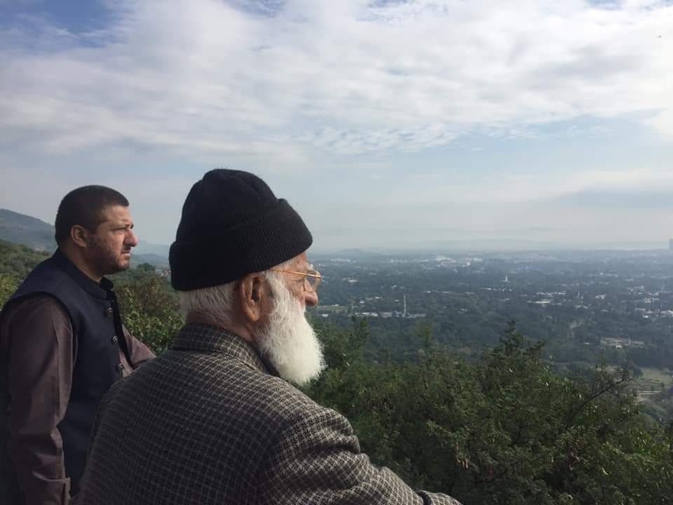 With another person at a hilltop viewpoint.